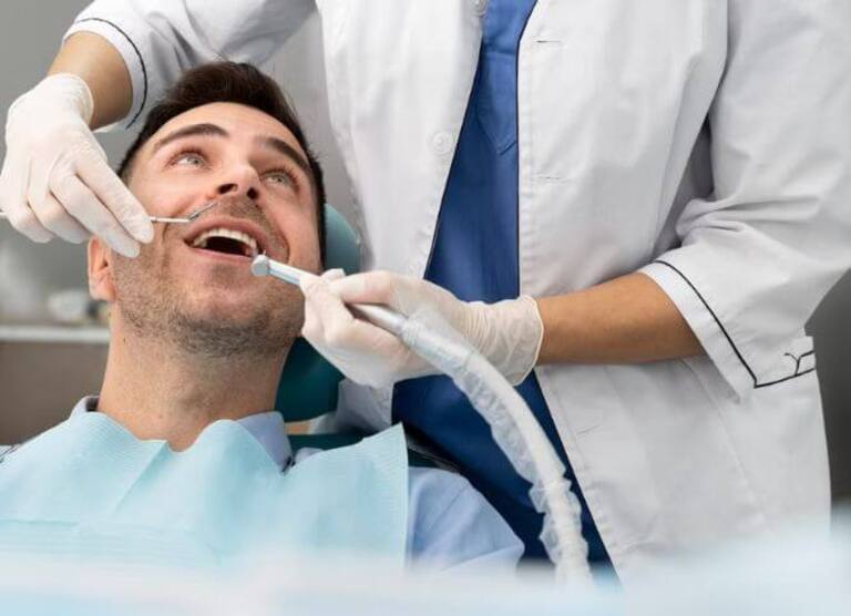 Homem sentado na cadeira do dentista